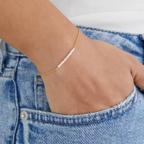 light weight bracelet wearing woman with her hand in her blue jeans pockets